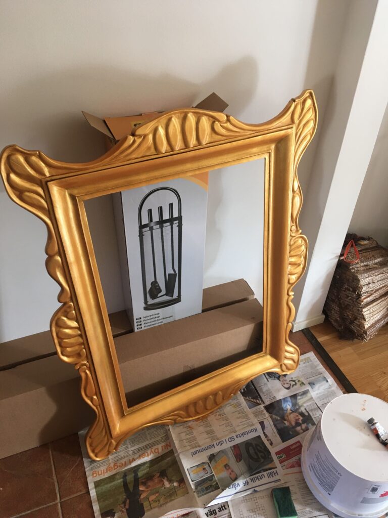 golden frame laying next to the wall